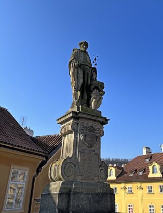 Baroque stone statue of saint Nicolas on the Charles Bridge of Prague