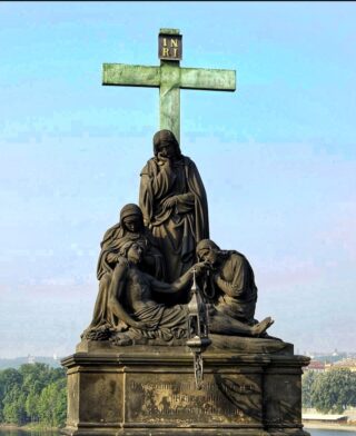 Stone statue of Pieta on the Charles Bridge of Prague