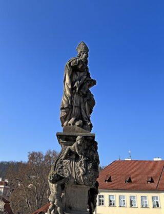 Baroque stone statue of saint Adalbert on the Charles Bridge of Prague